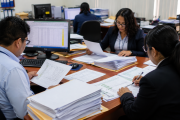 Trabajadores del sector público revisando documentos sobre gratificación y CTS CAS. Trabajadores del sector público revisando documentos sobre gratificación y CTS CAS.