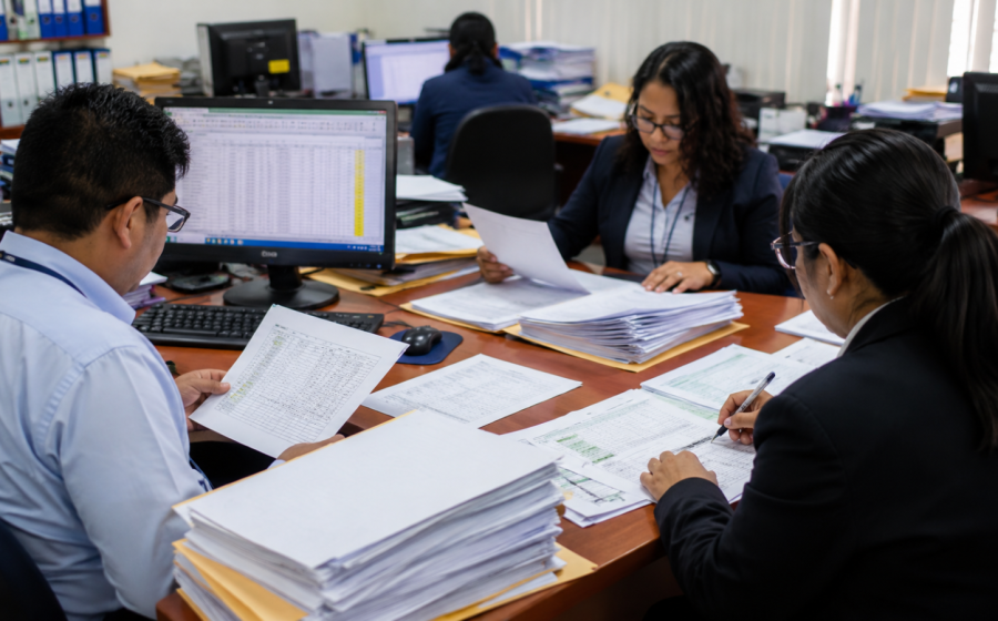 Trabajadores del sector público revisando documentos sobre gratificación y CTS CAS.